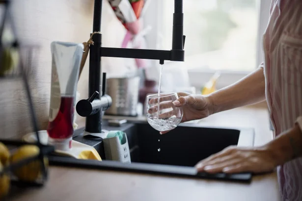 A glass being filled with tap water at a kitchen sink - Habit, Taste and Trust: The Real Reasons Bottled Water Endures