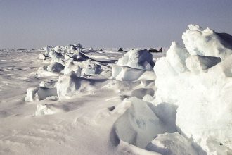 broken arctic sea ice floating on dark ocean water