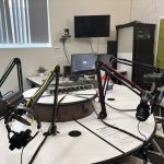 A podcast host recording in a studio with professional microphones