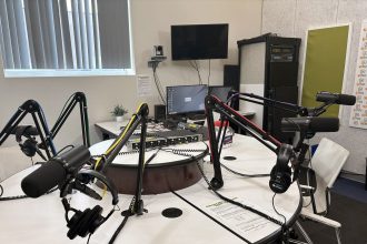 A podcast host recording in a studio with professional microphones
